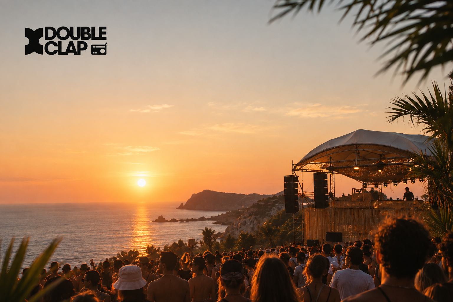 DJ playing at sunset over the ocean, crowd watching from a clifftop stage under palm trees
